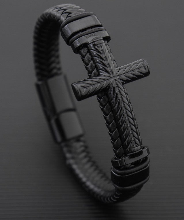 Black braided bracelet with a cross design on a dark background