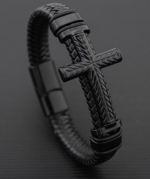 Black braided bracelet with a cross design on a dark background