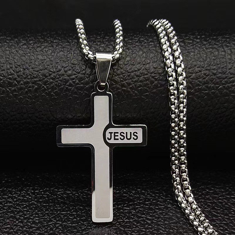 Silver cross pendant with 'JESUS' engraving on a black textured background