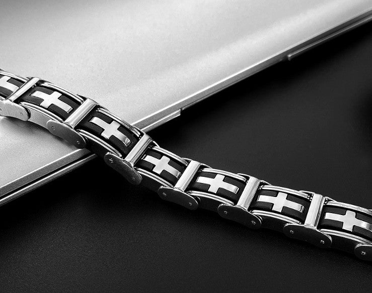 Bracelet with metal links and cross patterns on a dark surface