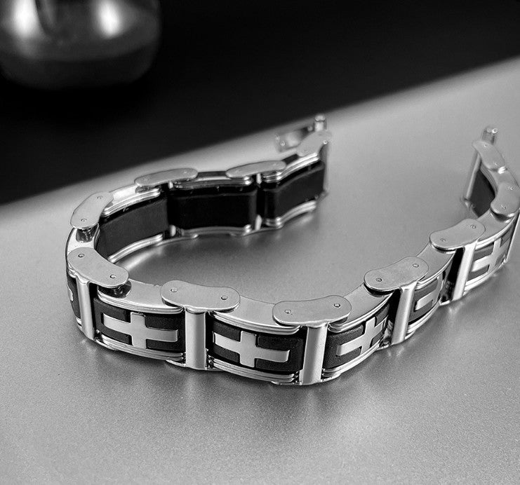 Metallic bracelet with black accents on a reflective surface