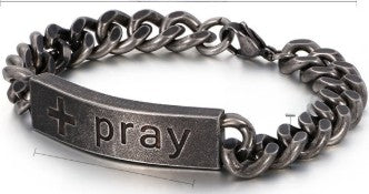 Metallic chain bracelet with 'pray' engraving on a white background