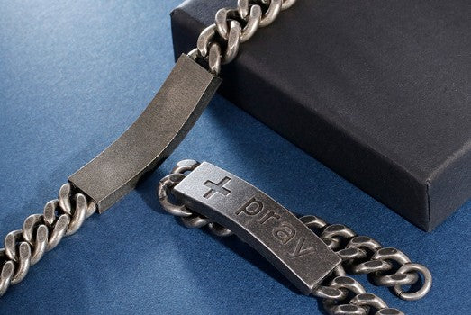 Silver chain with a branded clasp on a blue surface