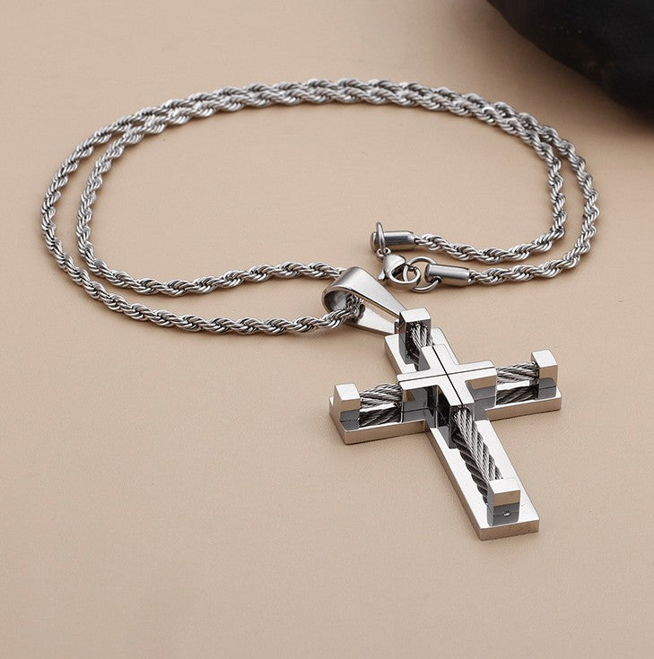Silver cross pendant necklace on a beige background