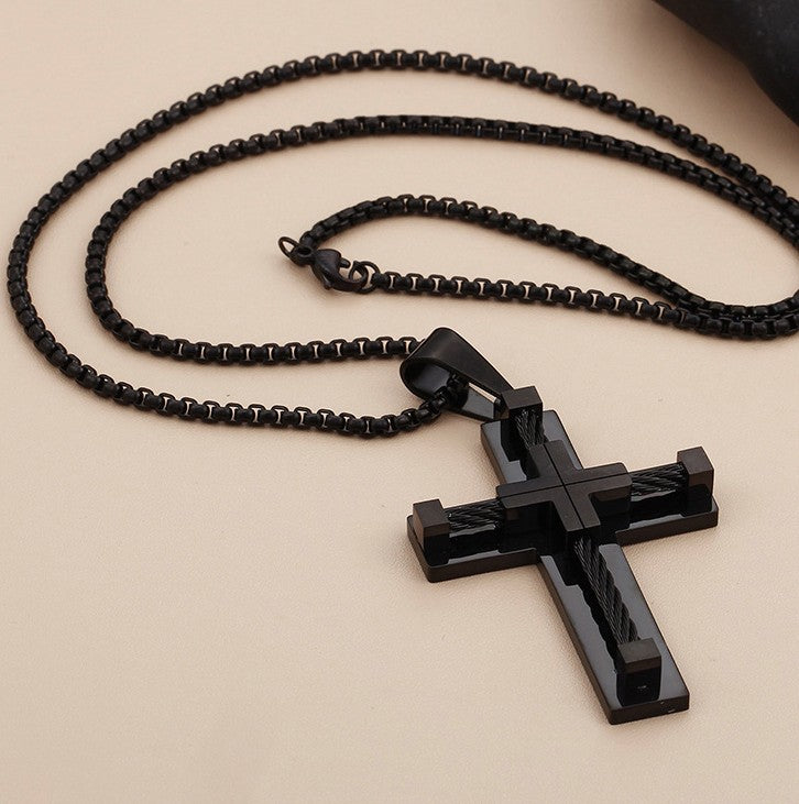 Black cross pendant necklace on a beige background