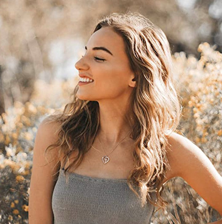 Woman with long blonde hair smiling outdoors with blurred natural background
