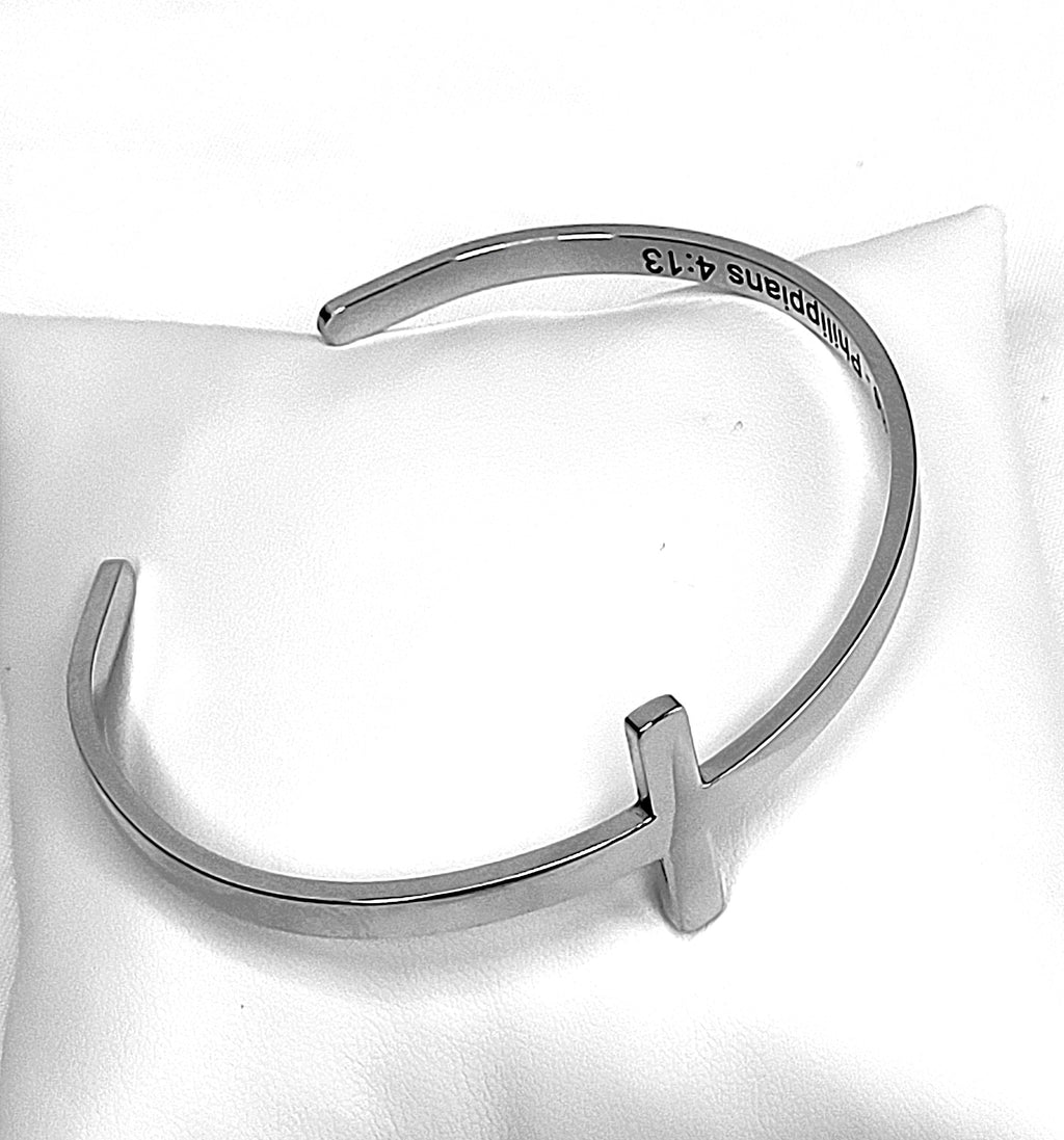 Silver bracelet on a white cushion with visible Bible scripture.