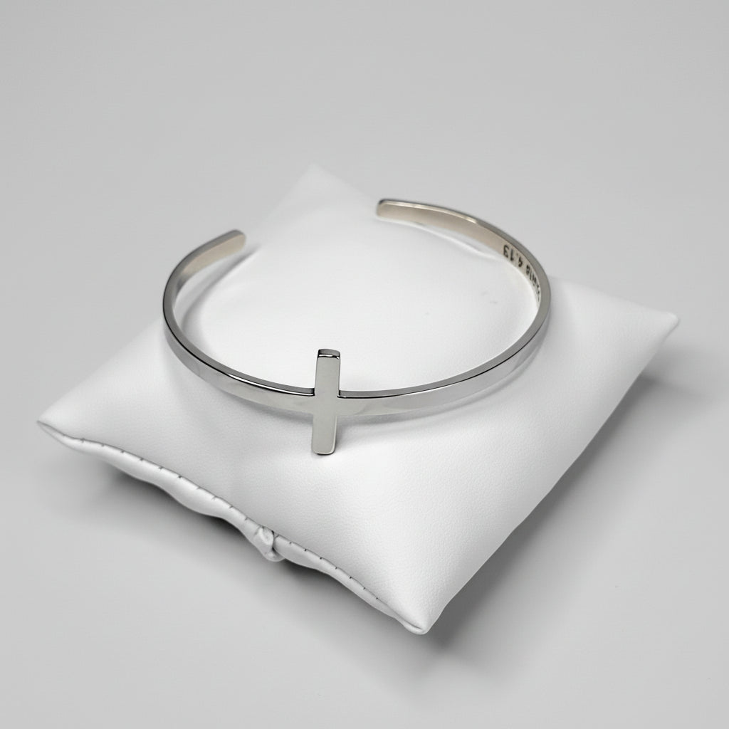Silver bracelet on a white cushion with a white background