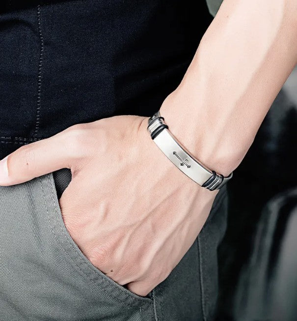 Close-up of a wrist wearing a silver bracelet with a dark background