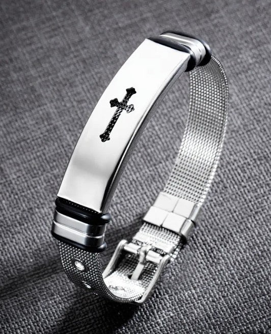 Silver bracelet with a cross design on a gray textured background