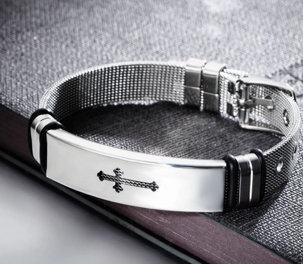 Silver bracelet with a cross emblem on a textured surface