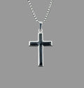 Silver cross pendant on a chain against a gray background