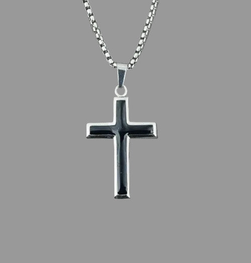 Silver cross pendant on a chain against a gray background