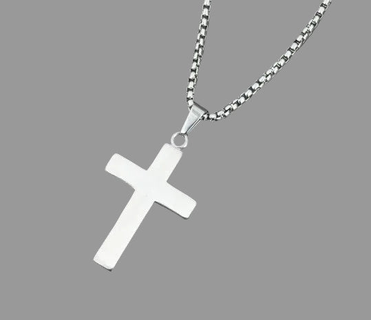 Silver cross pendant on a chain against a gray background