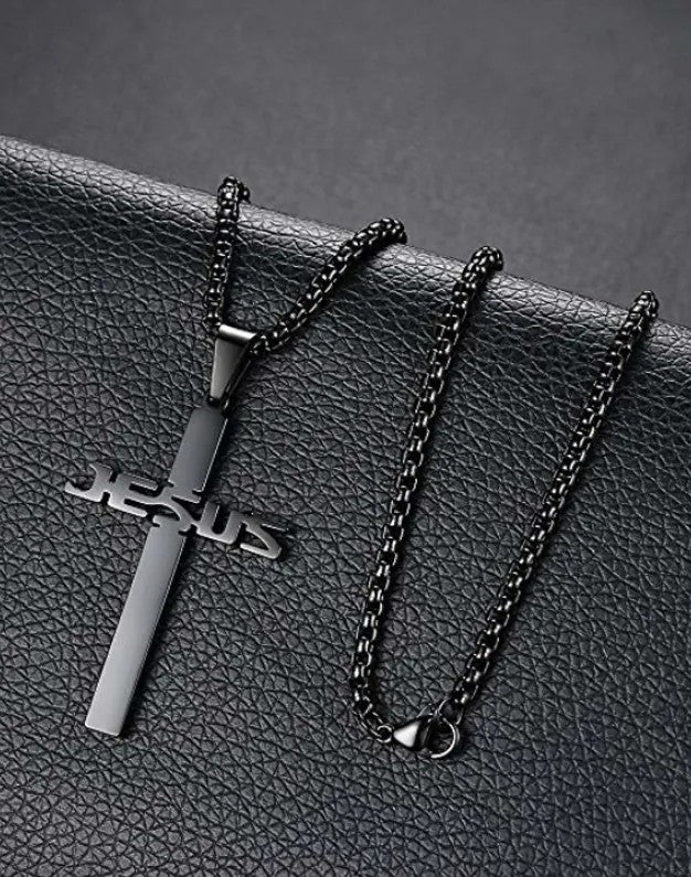Black 'Jesus' cross necklace on a textured black surface