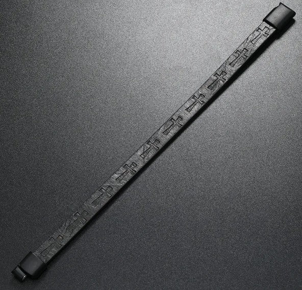 Black leather bracelet with embossed pattern on a gray background