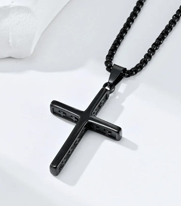 Black cross pendant necklace on a white background