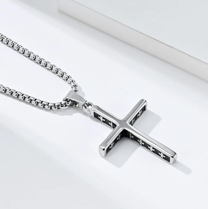 Silver cross necklace on a white background