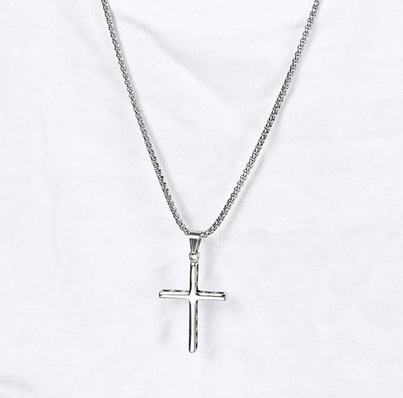Silver cross necklace on a white background