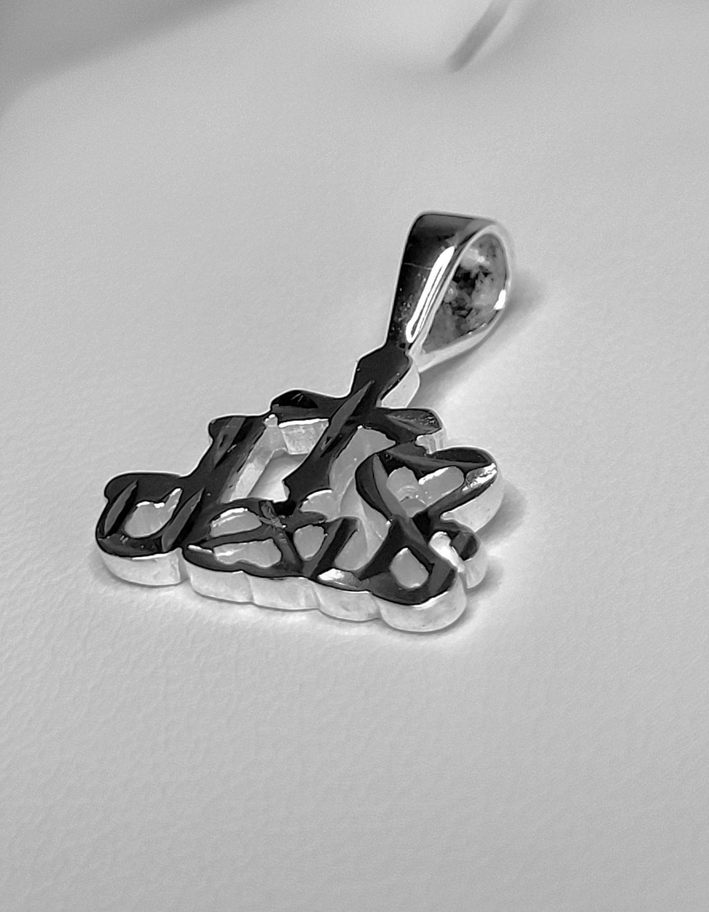 Silver pendant on a light gray background