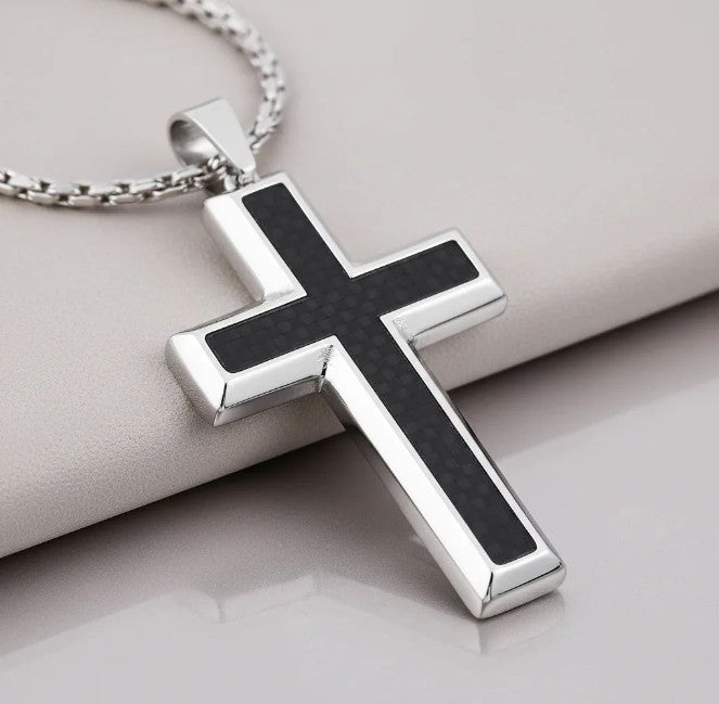 Silver cross pendant with black carbon fiber inlay on a light gray background