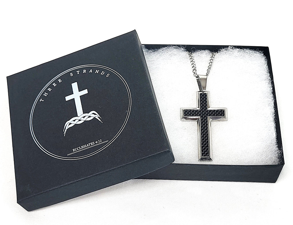 Black cross necklace in a Three Strands box on a white background