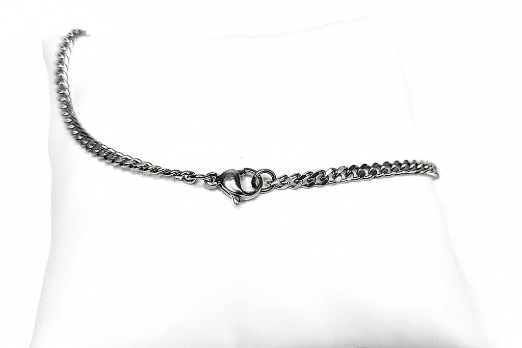 Silver chain diamond cut curb necklace on a white cushion
