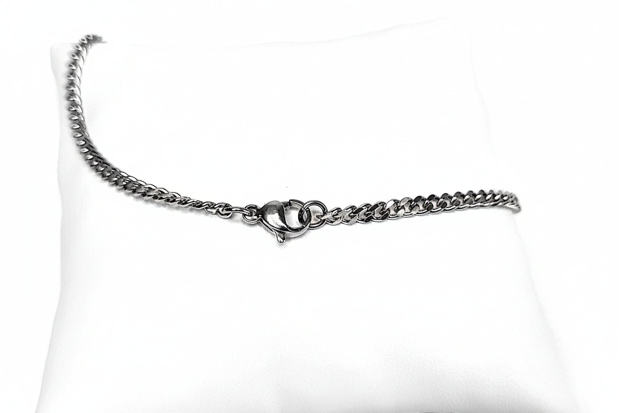 Silver chain diamond cut curb necklace on a white cushion