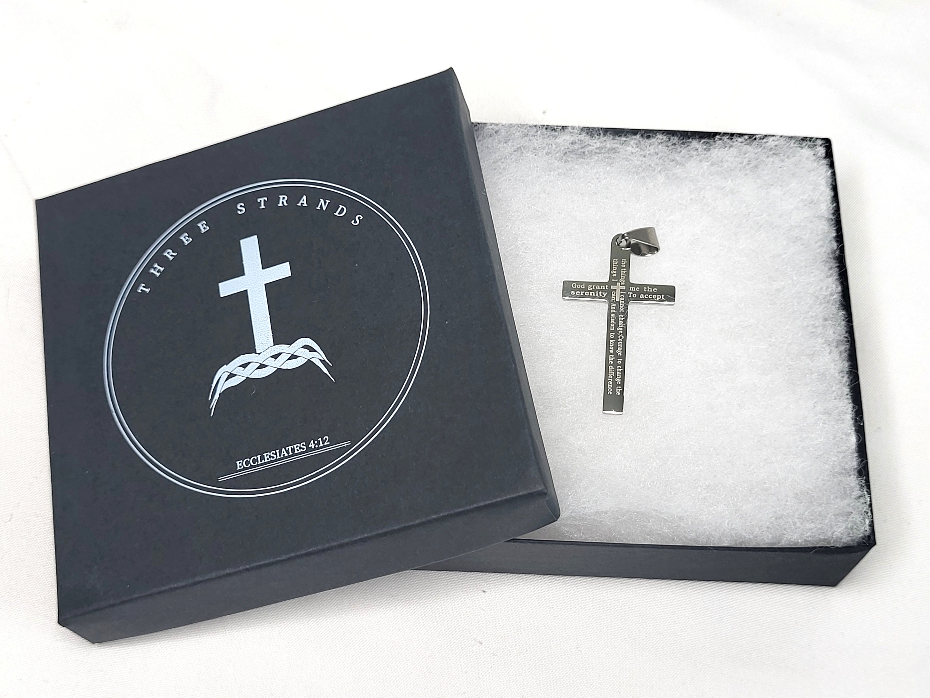 Black Three Strands jewelry box with a cross pendant on a white background
