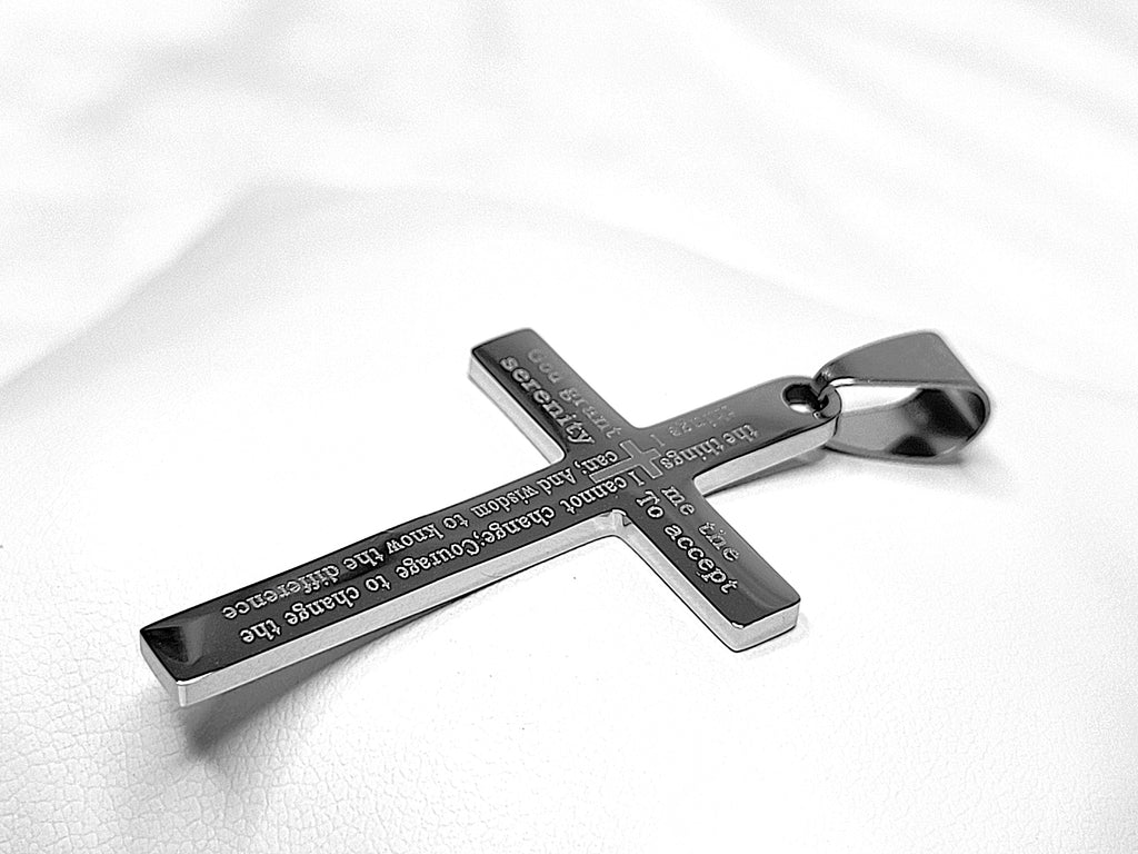 Silver cross pendant with engraved text on a white background