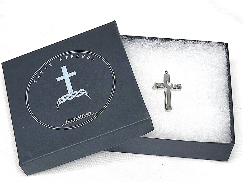 Silver cross pendant in a black jewelry box with brand logo.