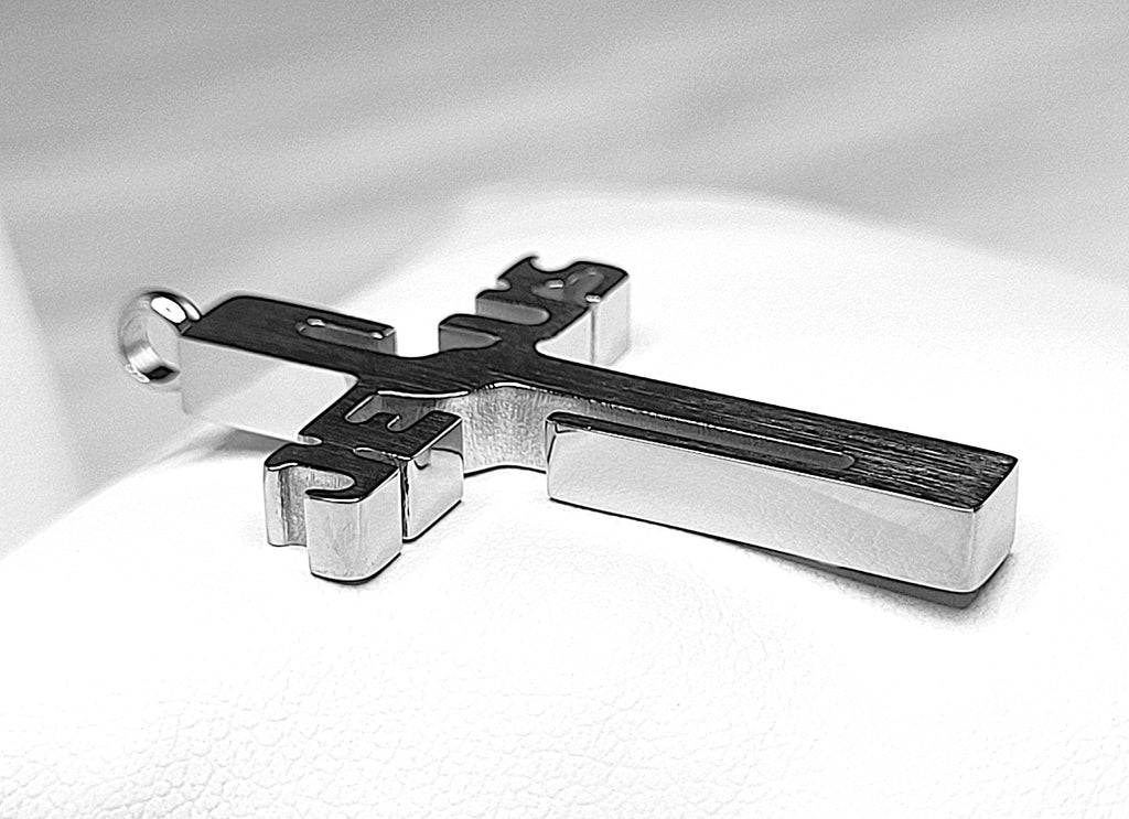 Silver Jesus pendant from its side on a white background