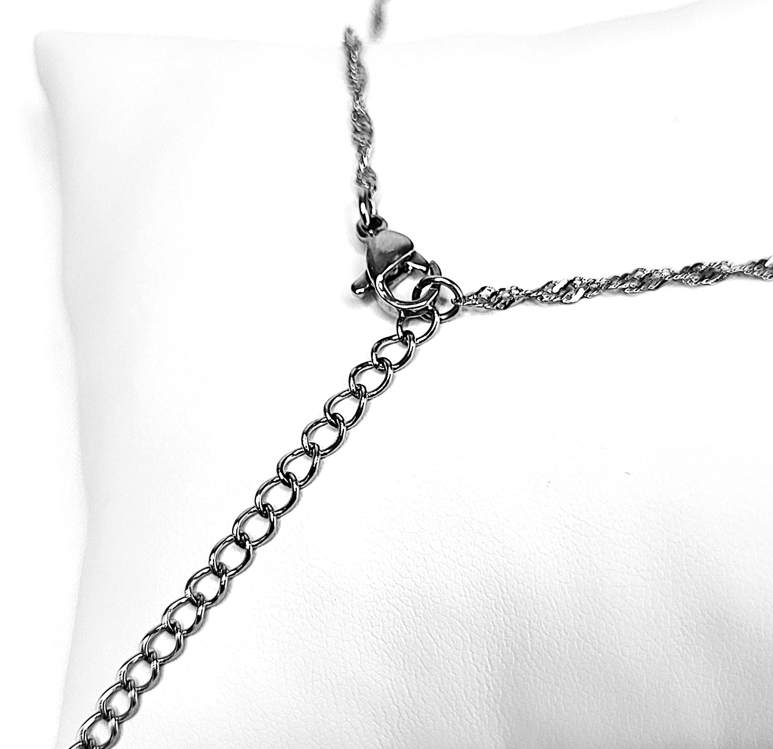 Close-up of a silver chain necklace on a white background